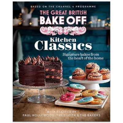 Cover of The Great British Bake Off: Kitchen Classics cookbook showing a chocolate layer cake, decorated cookies, and pastries on a table with a dark blue kitchen background—perfect for baking gifts or gift ideas for women who love to bake. gift idea