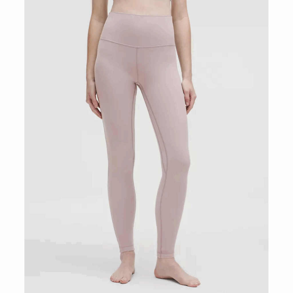A person stands barefoot, wearing high-waisted, light mauve leggings and a matching cropped top—an effortless look that also makes a thoughtful gift idea—visible from shoulders to feet against a plain white background. alwaysagift.co.uk