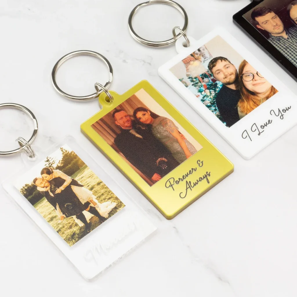 Three personalized keychains with photos of couples make thoughtful gifts. Each features a different frame color and inscription, including Married, Forever & Always, and I Love You. Perfect for Father’s Day gifts or special occasions. Arranged on a white surface. gift idea
