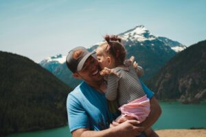 happy dad holding daughter outdoors