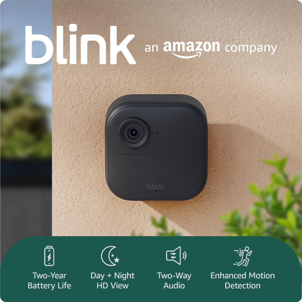 A Blink security camera is mounted on a beige wall next to green plants, seamlessly integrated with Elementor. Text highlights features: two-year battery life, day and night HD view, two-way audio, and enhanced motion detection. alwaysagift.co.uk