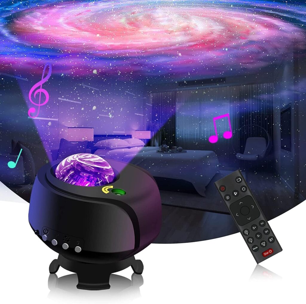 A galaxy projector with a glowing dome displays colorful nebula and star patterns on a bedroom ceiling. Musical notes indicate built-in speakers. A black remote control is shown in front—one of the best gifts 2025 for curious minds. alwaysagift.co.uk