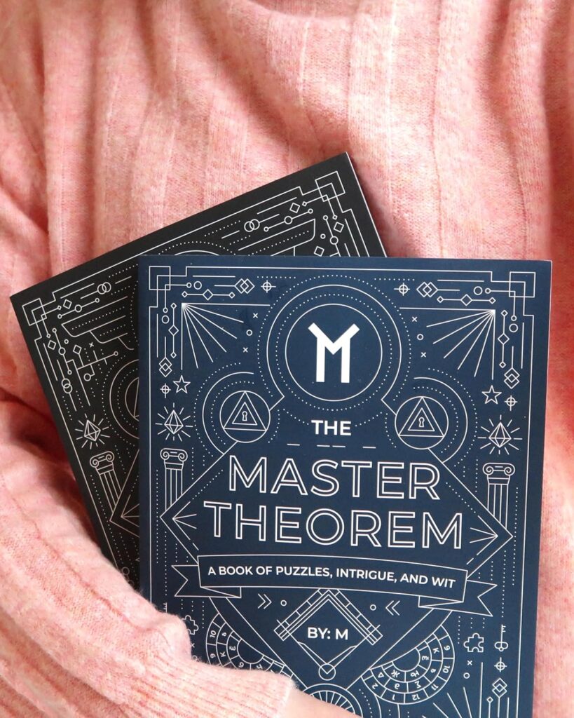 A person wearing a pink sweater holds two copies of The Master Theorem: A Book of Puzzles, Intrigue, and Wit by M, featuring a blue geometric cover—one of the best gifts 2025 for curious minds seeking intellectual challenges. alwaysagift.co.uk
